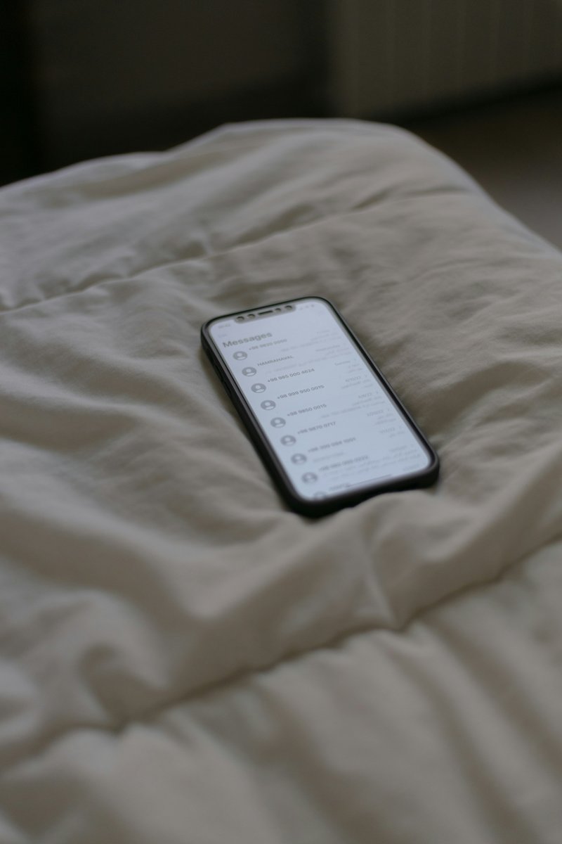 Téléphone posé sur une couette blanche